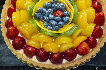 big round colorful fruit costarred dessert pie with many fruit colors and crust