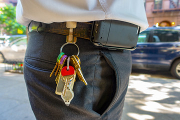 overweight worker with uniform and hanging access keys and cell phone clip