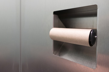 public bathroom inside stainless steel stall   and no toilet paper just an empty roll
