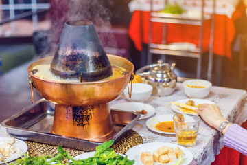 Asian traditional double hot pot close-up with lettuce leaves
