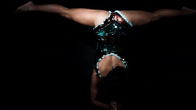 amazing female yoga instructor moving between poses in sparkling costume