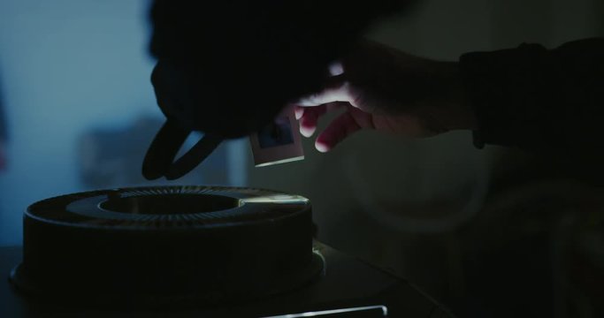 Man Operating Analog Slides Projector In A Dark Misty Room