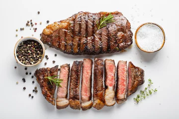 Foto op Canvas Two grilled marbled beef steaks striploin with spices isolated on white background, top view © Vasiliy