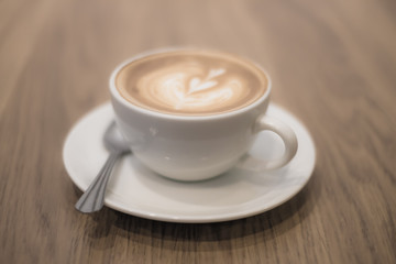 Latte art coffee on the wood table.
