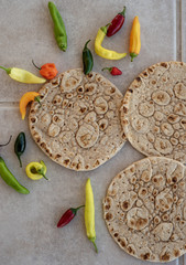 Naan flatbread with red, green, yellow, and orange chili peppers