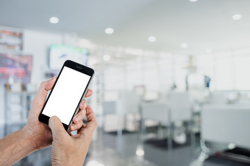 Man hands using smart phone with blurred coffee shop background. Blank screen for graphics display montage.