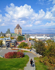 Fototapeta premium Quebec City, Quebec - October 12th, 2013: A young tourist begins her walk to the Fairmont Le Château Frontenac and the boardwalk along the St. Lawrence River