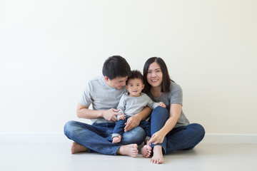 Happy asian family with one baby boy having fun together on floor