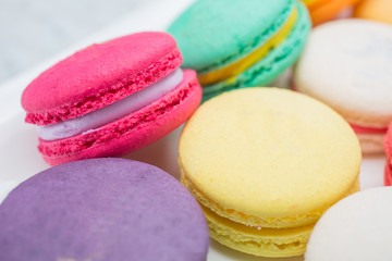 colorful magaroon is placed in a white ceramic dish. Elegant marble dining table with coffee table.