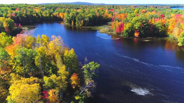 Autumn in Northern Wisconsin, colorful scenic treetop drone flyover of amazing forests and river.