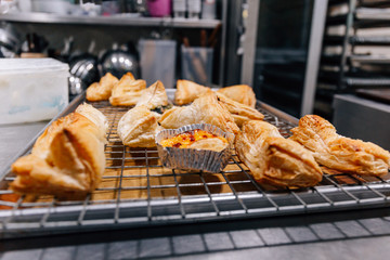 Close-up of many handmade breads on tray freshly baked from over in kitchen for commercial bakery shop.