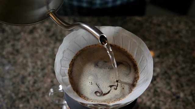 Barista pouring water on coffee ground with filter. Slow motion. Hd