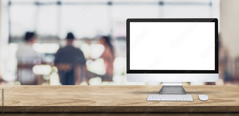 Aufkleber Blank screen desktop computer on wooden table top with blur people working at creative office bokeh background,Mock up for display or montage of design.
