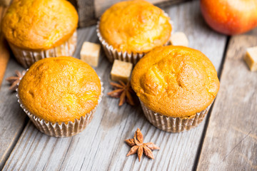 Homemade atutumn muffins with pumpkin, apples and spices on the rustic background. Selective focus. 