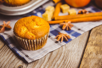 Homemade atutumn muffins with pumpkin, apples and spices on the rustic background. Selective focus. 