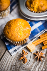 Homemade atutumn muffins with pumpkin, apples and spices on the rustic background. Selective focus. 