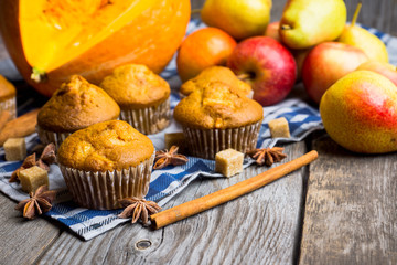 Homemade atutumn muffins with pumpkin, apples and spices on the rustic background. Selective focus. 