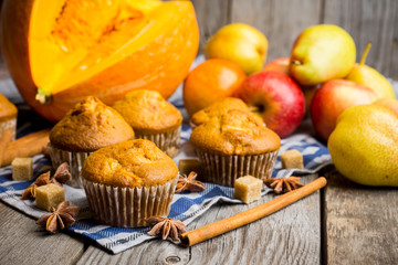Homemade atutumn muffins with pumpkin, apples and spices on the rustic background. Selective focus. 