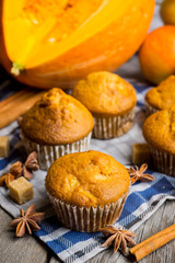 Homemade atutumn muffins with pumpkin, apples and spices on the rustic background. Selective focus. 