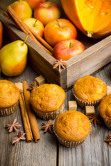 Homemade atutumn muffins with pumpkin, apples and spices on the rustic background. Selective focus. 