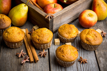 Homemade atutumn muffins with pumpkin, apples and spices on the rustic background. Selective focus. 