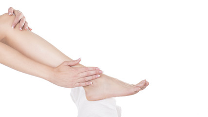 Woman applying cream on her beautiful feet