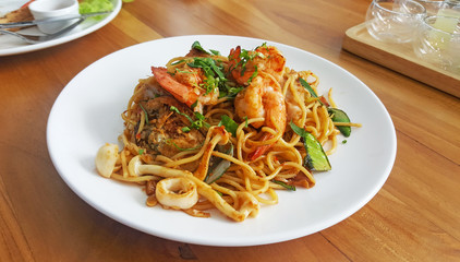 Seafood spicy spaghetti with garlic sauce on white plate