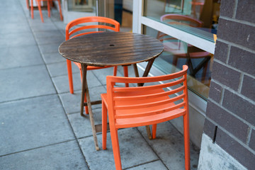 A wooden table with orange chairs outside of the Pearl district in downtown Portland, Oregon.