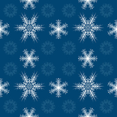 Seamless Christmas pattern with white and blue snowflakes on a dark blue background for the design of the New Year holidays
