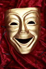 Comedy mask on red velvet fabric