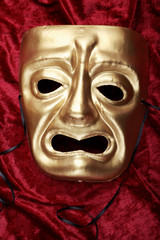 Tragedy mask on red velvet fabric