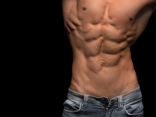 Muscular male torso isolated on black background.