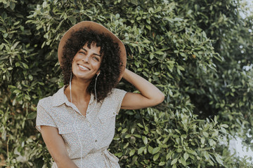 Beautiful woman listening to music in a botanical garden