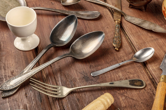 A photo of many vintage kitchen objects and cutlery from an old restaurant, flea market stuff on a wooden background