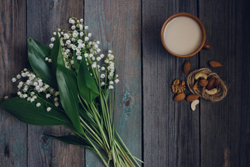 a Cup of tea, nuts, bouquet of lilies on a wooden table