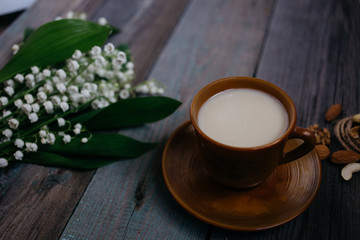 a Cup of tea, nuts, bouquet of lilies on a wooden table