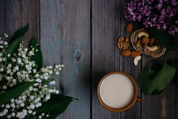 a Cup of tea, nuts, bouquet of lilies on a wooden table