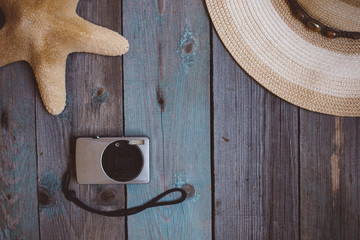 a hat, camera, a starfish, on the wooden background