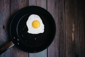 fried eggs in a frying pan on a wooden table, Breakfast, top view