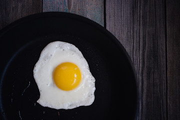 fried eggs in a frying pan on a wooden table, Breakfast, top view