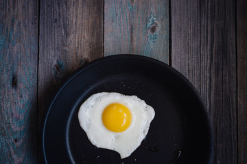 fried eggs in a frying pan on a wooden table, Breakfast, top view