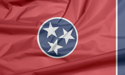 Fabric flag of Tennessee. Crease of Tennessee flag background, A blue circle with three white stars on red rectangular, with a strip of white and blue.