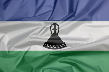 Fabric flag of Lesotho. Crease of Bosotho flag background, blue white and green with a black mokorotlo (a Basotho hat).
