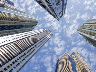 Dramatic perspective with low angle view of skyscrapers looking up to the sky. Vanishing point