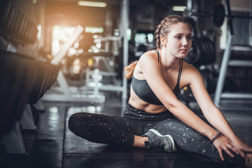 Cinematic tone of young attractive fitness woman exercise with machine in gym. Individual sport to fit muscles of body for healthy life concept.  