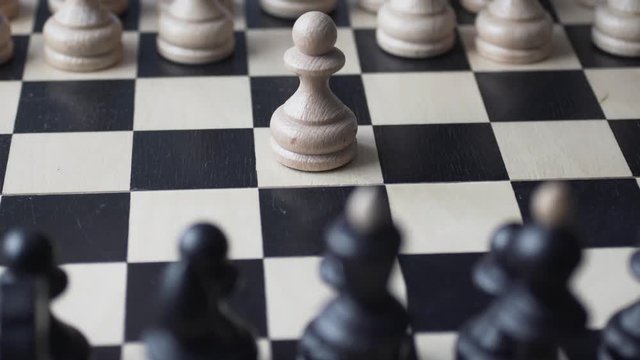Beginning of the game. White to move. The male hand moves the white pawn 2 squares forward. Chess