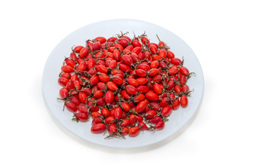 Dried red rose hips on the white dish