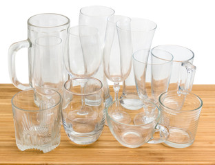 Different empty glass utensils on a wooden surface