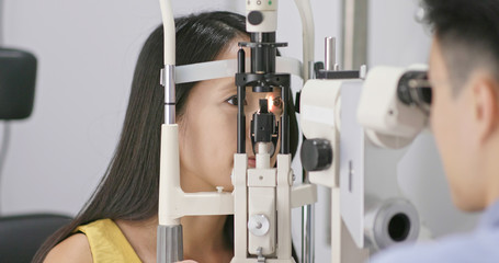 Woman checking on eye in clinic