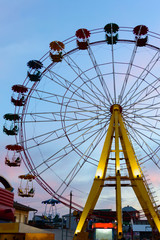 Amusement park on the background of the sunset. Ferris wheel